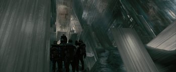 Movie still from “Superman Returns” (2006), directed by Bryan Singer – A group of people standing next to each other in front of a wall; Wide shot, Low angle