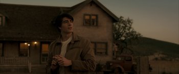 Movie still from “Superman Returns” (2006), directed by Bryan Singer – A man standing in front of an old house; Medium shot, Low angle