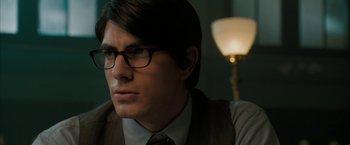 Movie still from “Superman Returns” (2006), directed by Bryan Singer – A person wearing a suit and glasses; Close Up shot, Over the shoulder angle