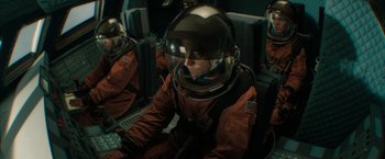 Movie still from “Superman Returns” (2006), directed by Bryan Singer – A man in a space suit sitting in an airplane; Medium shot, Overhead angle