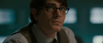 Movie still from “Superman Returns” (2006), directed by Bryan Singer – A person wearing a suit and glasses; Close Up shot, Over the shoulder angle