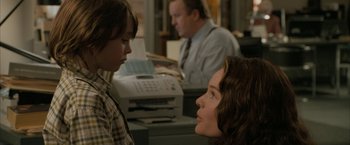 Movie still from “Superman Returns” (2006), directed by Bryan Singer – Two young people looking at each other in front of a printer; Close Up shot, Over the shoulder angle