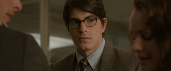 Movie still from “Superman Returns” (2006), directed by Bryan Singer – A man in a suit and tie wearing glasses; Close Up shot, Over the shoulder angle