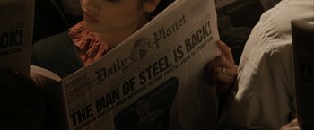 Movie still from “Superman Returns” (2006), directed by Bryan Singer – A person reading a newspaper in a dark room; Extreme Close Up shot, High angle