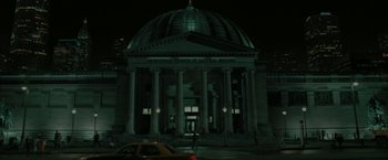 Movie still from “Superman Returns” (2006), directed by Bryan Singer – A car parked on the side of the road in front of a building; Extreme Wide shot, Low angle