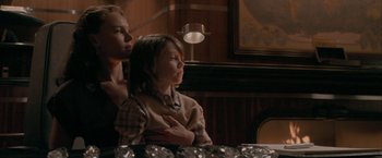 Movie still from “Superman Returns” (2006), directed by Bryan Singer – A woman and a child sitting at a table; Medium shot, Over the shoulder angle