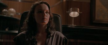 Movie still from “Superman Returns” (2006), directed by Bryan Singer – A woman sitting in a chair in front of a lamp; Close Up shot, Over the shoulder angle