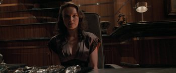 Movie still from “Superman Returns” (2006), directed by Bryan Singer – A woman sitting at a table in front of a plate of food; Medium shot, Over the shoulder angle