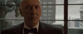 Movie still from “Superman Returns” (2006), directed by Bryan Singer – An older man wearing a suit and a bow tie; Close Up shot, Low angle