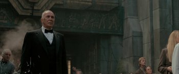 Movie still from “Superman Returns” (2006), directed by Bryan Singer – A man standing in front of a group of people in front of a building; Medium shot, Low angle