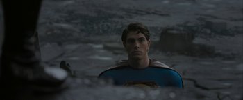 Movie still from “Superman Returns” (2006), directed by Bryan Singer – A man wearing a superman costume standing in water; Medium shot, Over the shoulder angle