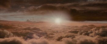 Movie still from “Superman Returns” (2006), directed by Bryan Singer – A person standing on top of a cloud filled sky; Extreme Wide shot, Low angle