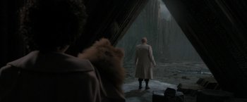 Movie still from “Superman Returns” (2006), directed by Bryan Singer – A man in a trench coat is holding a teddy bear; Wide shot, Over the shoulder angle