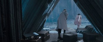 Movie still from “Superman Returns” (2006), directed by Bryan Singer – A man in a white coat standing in front of an ocean; Wide shot, High angle