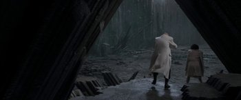 Movie still from “Superman Returns” (2006), directed by Bryan Singer – Two people walking in the rain near a forest; Wide shot, High angle