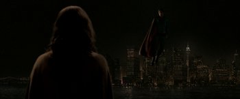 Movie still from “Superman Returns” (2006), directed by Bryan Singer – A man flying through the air while a woman looks on; Wide shot, Over the shoulder angle