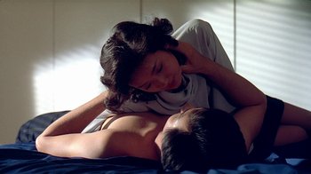 Movie still from “Eat Drink Man Woman” (1994), directed by Ang Lee – A man and a woman laying on a bed together; Medium shot, High angle