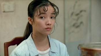Movie still from “Eat Drink Man Woman” (1994), directed by Ang Lee – A young asian woman with long black hair looking to her left; Close Up shot, Over the shoulder angle