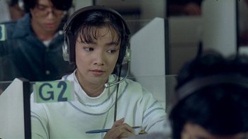Movie still from “Eat Drink Man Woman” (1994), directed by Ang Lee – A woman wearing headphones and holding a pen; Close Up shot, High angle