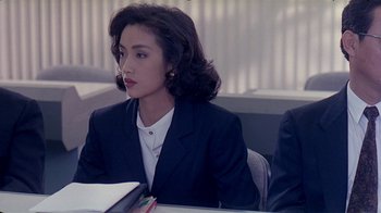 Movie still from “Eat Drink Man Woman” (1994), directed by Ang Lee – A woman sitting at a table in front of a book; Medium shot, Over the shoulder angle