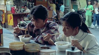 Movie still from “Eat Drink Man Woman” (1994), directed by Ang Lee – A man and a woman sitting at a table with bowls of food in front of them; Medium shot, High angle