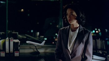 Movie still from “Eat Drink Man Woman” (1994), directed by Ang Lee – A woman standing in front of an airplane at an airport; Medium shot, Over the shoulder angle