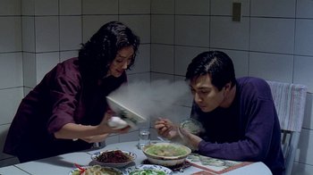 Movie still from “Eat Drink Man Woman” (1994), directed by Ang Lee – A man and a woman sitting at a table with food; Medium shot, High angle