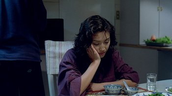 Movie still from “Eat Drink Man Woman” (1994), directed by Ang Lee – A woman sitting at a table with a bowl in front of her; Medium shot, High angle