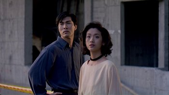 Movie still from “Eat Drink Man Woman” (1994), directed by Ang Lee – A man and a woman standing next to each other in front of a building; Medium shot, Low angle