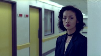 Movie still from “Eat Drink Man Woman” (1994), directed by Ang Lee – A woman standing in front of a yellow door; Close Up shot, Over the shoulder angle