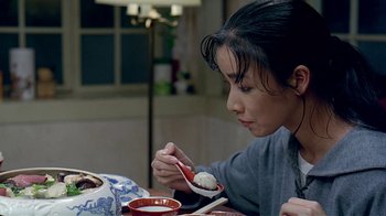 Movie still from “Eat Drink Man Woman” (1994), directed by Ang Lee – A woman sitting at a table eating a dessert; Close Up shot, High angle