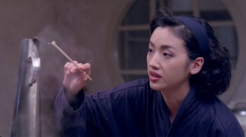 Movie still from “Eat Drink Man Woman” (1994), directed by Ang Lee – A woman holding a chopstick in her right hand; Close Up shot, Over the shoulder angle