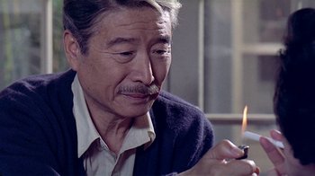 Movie still from “Eat Drink Man Woman” (1994), directed by Ang Lee – An older man lighting a candle in a candle holder; Close Up shot, Over the shoulder angle