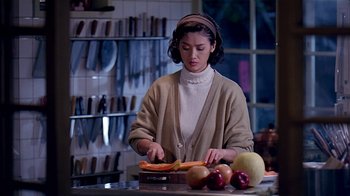 Movie still from “Eat Drink Man Woman” (1994), directed by Ang Lee – A woman cutting a piece of fruit on a cutting board; Medium shot, Over the shoulder angle