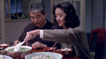 Movie still from “Eat Drink Man Woman” (1994), directed by Ang Lee – A man and a woman sitting at a dinner table; Medium shot, High angle