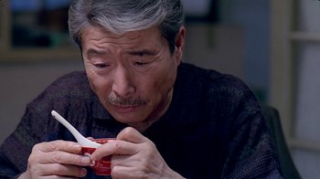 Movie still from “Eat Drink Man Woman” (1994), directed by Ang Lee – An older man holding a cup of coffee and a spoon; Close Up shot, High angle