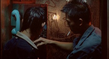 Movie still from “Rebels of the Neon God” (1992), directed by Tsai Ming-liang – Two young men standing next to each other in front of a wall; Close Up shot, Over the shoulder angle