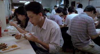 Movie still from “Rebels of the Neon God” (1992), directed by Tsai Ming-liang – A group of people sitting at a table eating food; Medium shot, High angle