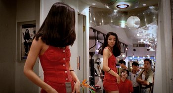 Movie still from “Rebels of the Neon God” (1992), directed by Tsai Ming-liang – A woman in a red dress looking in a mirror; Medium shot, Over the shoulder angle