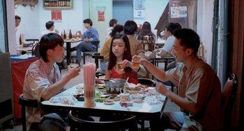 Movie still from “Rebels of the Neon God” (1992), directed by Tsai Ming-liang – A group of people sitting around a table eating food; Medium shot, High angle