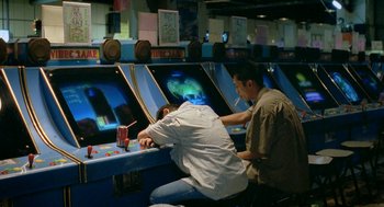 Movie still from “Rebels of the Neon God” (1992), directed by Tsai Ming-liang – Two men are playing a video game in an arcade; Wide shot, High angle