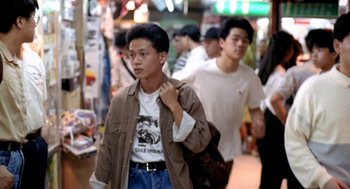 Movie still from “Rebels of the Neon God” (1992), directed by Tsai Ming-liang – A young man walking down a crowded street; Medium shot, Over the shoulder angle