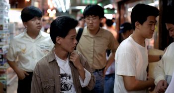 Movie still from “Rebels of the Neon God” (1992), directed by Tsai Ming-liang – A group of men standing next to each other on the street; Medium shot, High angle