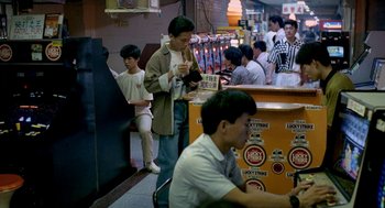 Movie still from “Rebels of the Neon God” (1992), directed by Tsai Ming-liang – A group of people standing in a room; Wide shot, High angle