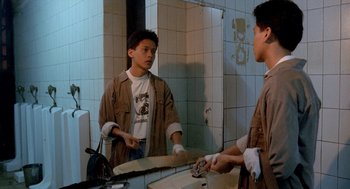 Movie still from “Rebels of the Neon God” (1992), directed by Tsai Ming-liang – A young man is looking at himself in the mirror in the bathroom; Medium shot, High angle