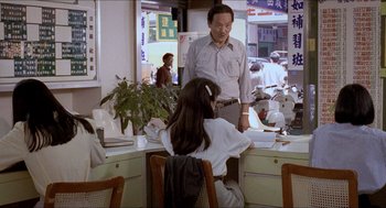 Movie still from “Rebels of the Neon God” (1992), directed by Tsai Ming-liang – A man and a woman are sitting at a table; Medium shot, High angle