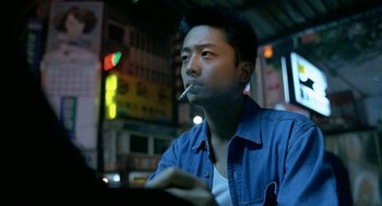A man sitting at a table with a cigarette in his mouth