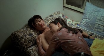 Movie still from “Rebels of the Neon God” (1992), directed by Tsai Ming-liang – A man and a woman laying on a bed; Medium shot, Overhead angle