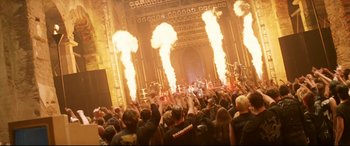 Movie still from “xXx” (2002), directed by Rob Cohen – A large crowd of people in front of a building with fire coming out of it; Wide shot, High angle