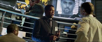 Movie still from “xXx” (2002), directed by Rob Cohen – A man in a suit and tie talking on a cell phone; Medium shot, Over the shoulder angle